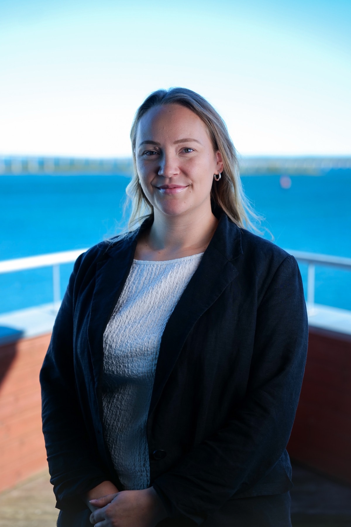 Emmy Andersson på balkongen med vattnet bakom