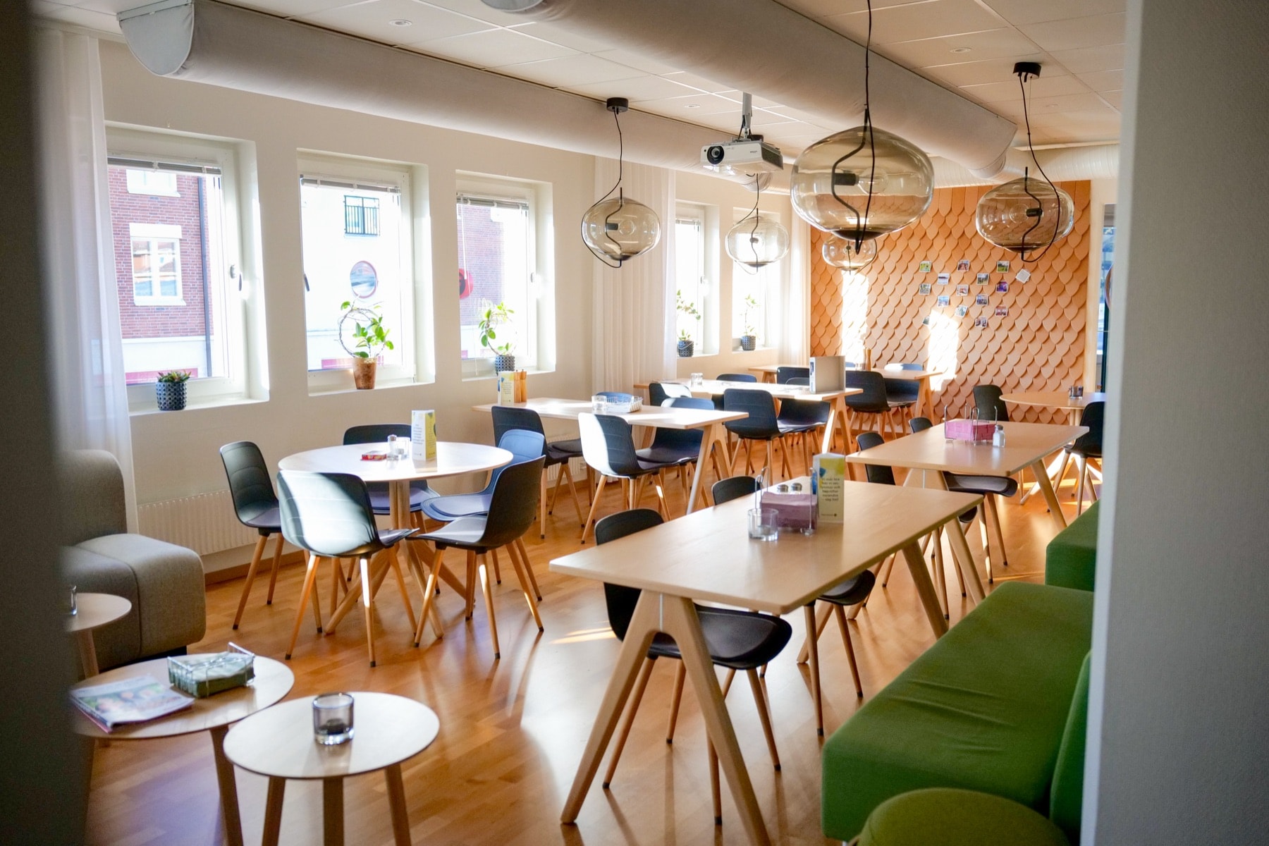 Lunchrummet med långbord och gröna soffor